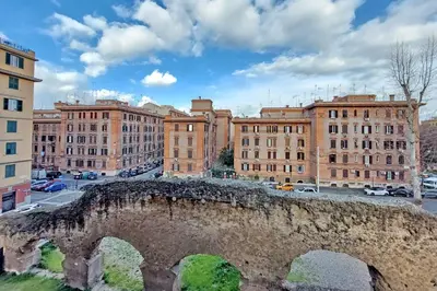an old stone bridge in a city with buildings at Testaccio Sweet Holiday Apt in Rome