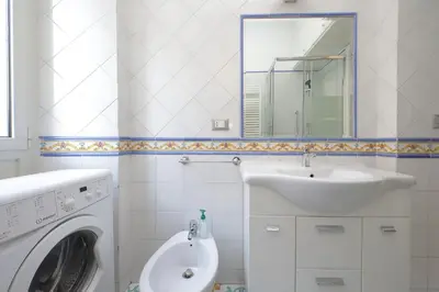 a bathroom with a sink and a washing machine at Testaccio Sweet Holiday Apt in Rome