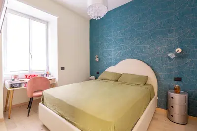 a bedroom with a bed and a blue wall at GuestHost - San Giovanni Comfy Apartment in Rome