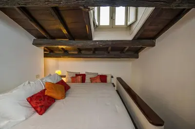 a bedroom with a large white bed with red pillows at Rooftop view house near Piazza Navona in Rome