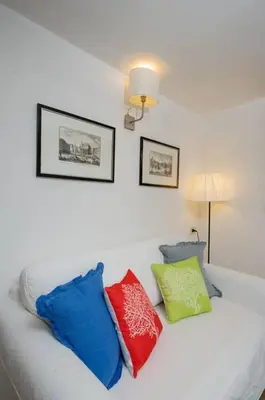 a white bed with four colorful pillows on it at Rooftop view house near Piazza Navona in Rome