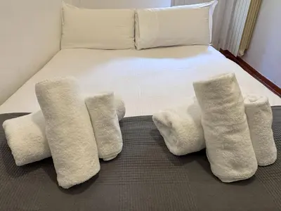 a bed with four white pillows on it at JHHIT - San Pietro First Suite in Rome