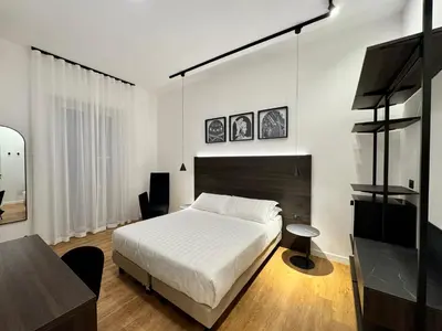 a bedroom with a bed and a table and a desk at Museum Hospitality - Vatican Apartments in Rome
