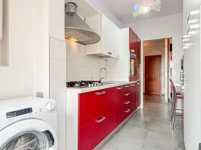 a kitchen with red cabinets and a washing machine at Portuense Paradise in Rome