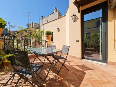 a glass table and chairs on a patio at CS Stylish Loft with Terrace Spanish Steps in Rome