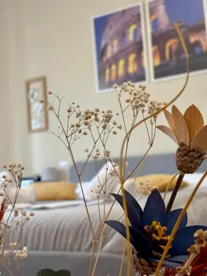 a vase with flowers in a room with a bed at Quattro Venti city suites in Rome