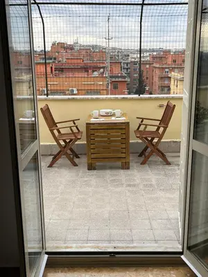 a patio with two chairs and a table on a balcony at L' attichetto in Rome