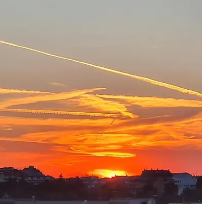 an airplane trails in the sky at sunset at L' attichetto in Rome