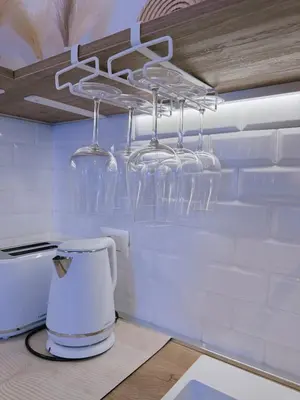 a kitchen with wine glasses hanging from a ceiling at Vacanze Romane House in Rome