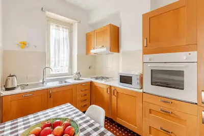 a kitchen with wooden cabinets and a table with a bowl of fruit at Casa Bella in Rome