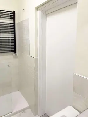 a white bathroom with a shower and a glass door at Domus Lucis Rome in Rome