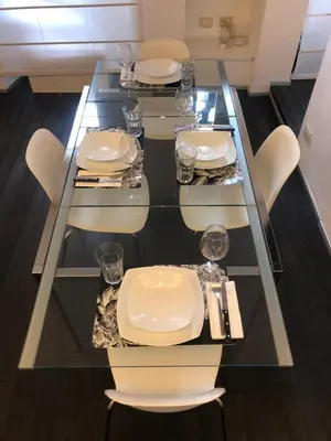 a glass table with white chairs and plates on it at Vatican 3th Floor in Rome
