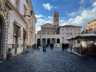 a group of people walking down a street with a clock tower at The Charm of Trastevere in Rome