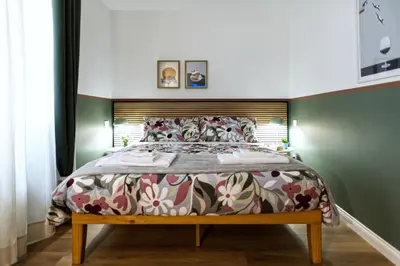 a bedroom with a large bed with a wooden headboard at Savi Guest House metro B S Paolo in Rome