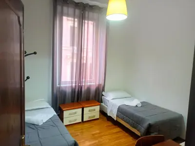 a bedroom with two beds and a window at Niam House in Rome