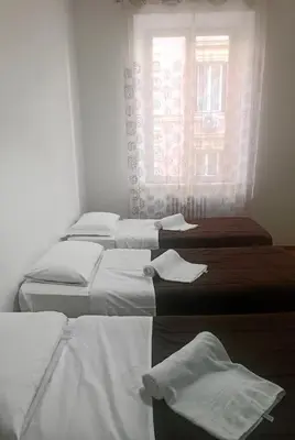 four beds in a room with a window at Niam House in Rome