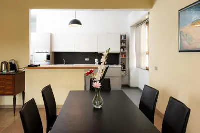 a dining room table with a vase of flowers on it at Laterani36 elegante Appartamento 3 Camere, sopra Metro Porta Metronia in Rome