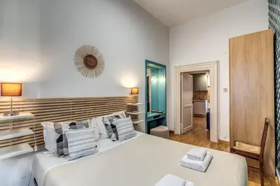 a bedroom with a large white bed with a wooden headboard at Fresh House Ludovisi in Rome