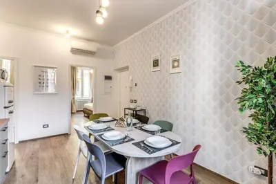 a dining room with a table and purple chairs at Casa Bixio Fantastico appartamento nel cuore di Roma in Rome