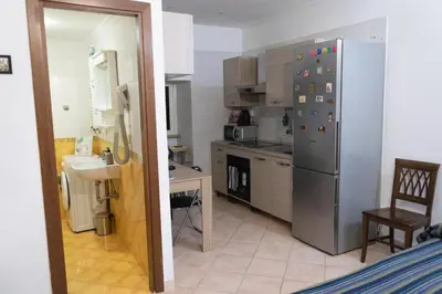 a kitchen with a stainless steel refrigerator and a sink at Casa di Roberto - Metro e Servizi a due passi! in Rome