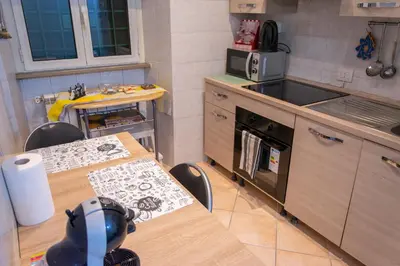 a small kitchen with a table and a stove top oven at Casa di Roberto - Metro e Servizi a due passi! in Rome