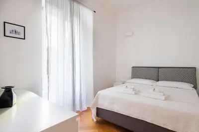 a white bedroom with a bed and a window at ST PETER APARTMENT metro at 3 minutes in Rome