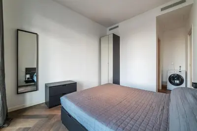 a bedroom with a bed and a dresser and a mirror at GuestHost - Ostiense Modern ApartamentS in Rome