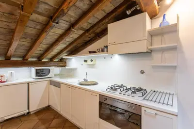 a kitchen with white appliances and wooden ceilings at Cozy Gambero Apartments in Rome