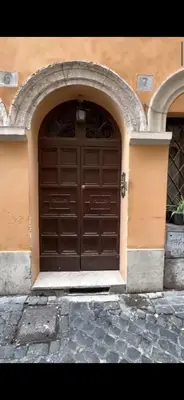 a large wooden door in a building with an arch at Welcome to Campo De' Fiori in Rome