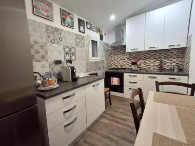 a small kitchen with white cabinets and a table at Imperial Apartment in Rome