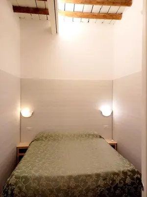a bedroom with a bed and two lights on the wall at Caprareccia Apartment in Rome