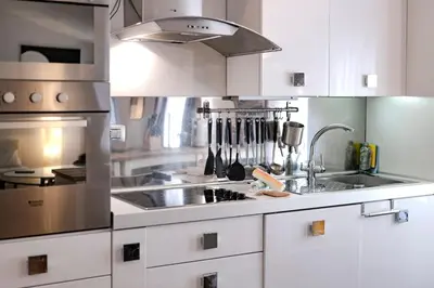 a kitchen with white cabinets and a stainless steel sink at Restart Accommodations Dea Roma in Rome