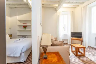 a bedroom and a living room with a bed and a table at Navona Urban Sanctuary in Rome