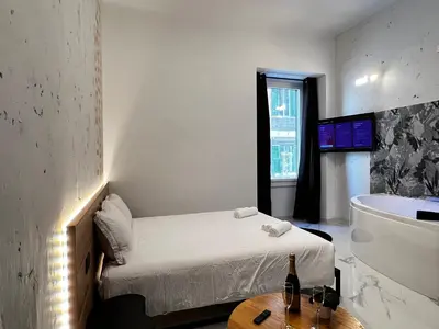 a room with a bed and a tub and a table at ESE luxury spa suites - Private Jacuzzi Rooms Near Termini, Perfect for Winter in Rome