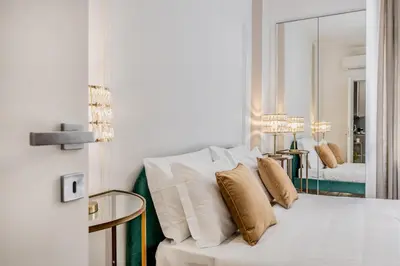 a bedroom with a white bed with pillows and a mirror at CdR 190 - Vaticano in Rome