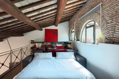 a bedroom with a bed and two windows at Monti Designer Loft by Romeloft in Rome