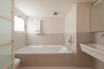 a white bathroom with a tub and a sink at Monti Designer Loft by Romeloft in Rome