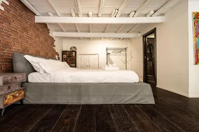 a bedroom with a large bed and a brick wall at Luxury Loft Campo Dè Fiori in Rome