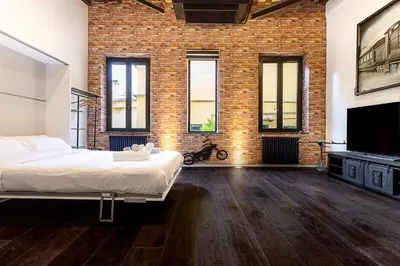 a bedroom with a large bed and a brick wall at Luxury Loft Campo Dè Fiori in Rome
