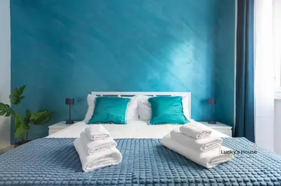 a blue bedroom with a bed with towels on it at Lucky's House - 400mt to Metro A, 3 bedrooms, 6-8 pax, A-C, Roma in Rome