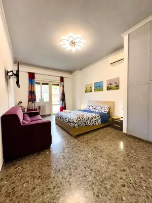 a bedroom with a bed and a couch and a chair at La casa di Ezechiele in Rome