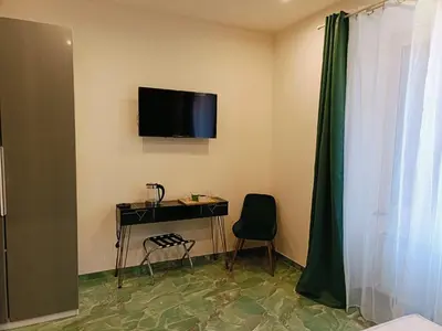 a room with a desk and a television on the wall at Cozy Luxury room San Pietro in Rome