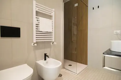 a bathroom with a white toilet and a sink at Lilla Suites - Musei Vaticani in Rome