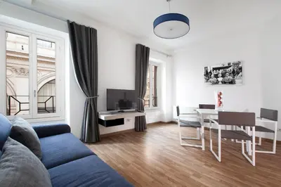 a living room with a couch and a dining room at Oriana Homèl Roma in Rome