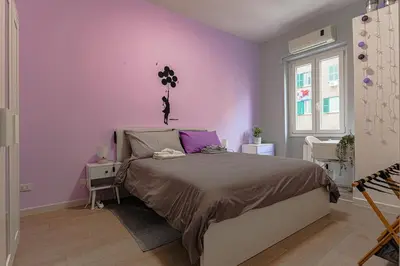 a bedroom with purple walls and a large bed at cosy apt close to metro San Paolo in Rome