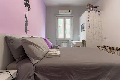 a bedroom with a large bed with purple walls at cosy apt close to metro San Paolo in Rome
