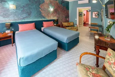 a room with two beds and a couch and a table at Tu chiamale emozioni intero appartamento in Rome