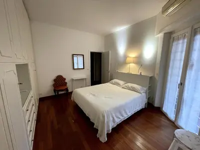 a white bedroom with a bed and a chair at Desy Vatican House in Rome