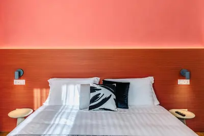 a bed with two pillows against a red wall at Rome at Home in Rome