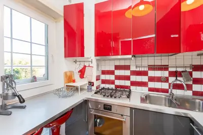 a kitchen with red cabinets and a sink at Trastevere Relax by Rental in Rome in Rome